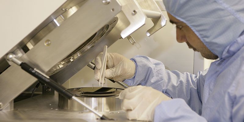 A nanotechnology researcher in protective clothing works with special equipment