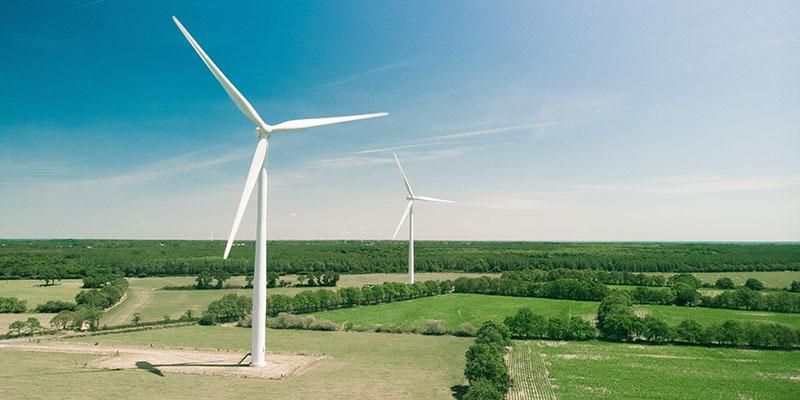 Wind turbines in a field under a blue sky