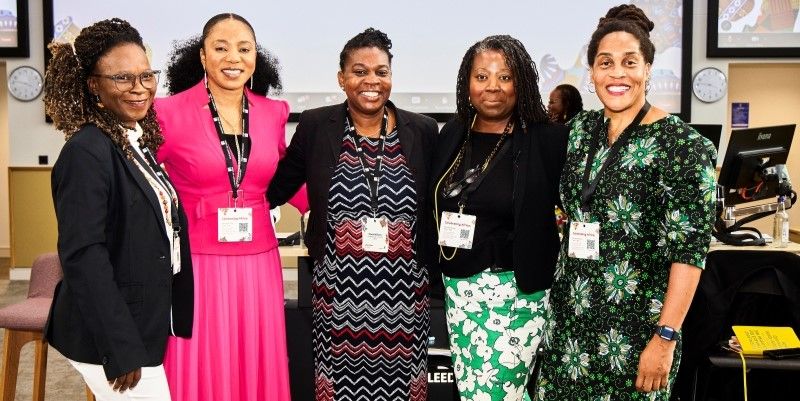 A group of five women smiling at the camera