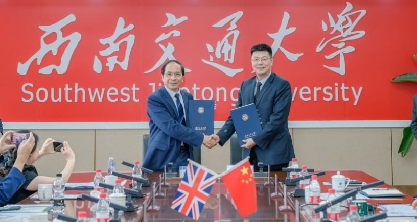 Professor Hai-Sui Yu with SWJTU President Xuedong Yan shaking hands and holding a strategic agreement.