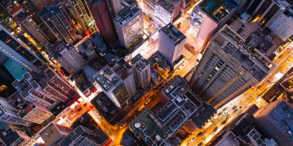 An aerial view of a busy city at night, with skyscrapers and bright lights.