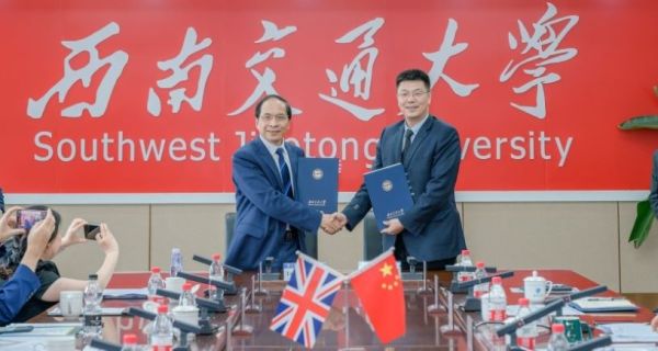 Professor Hai-Sui Yu with SWJTU President Xuedong Yan shaking hands and holding a strategic agreement.