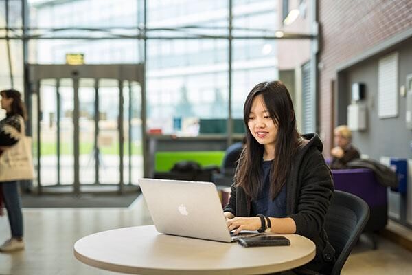 Student working on a laptop in the Business School