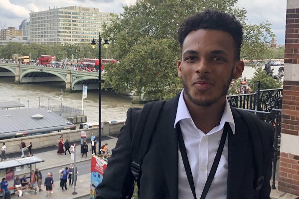 Josh King in front of a road bridge across a river.