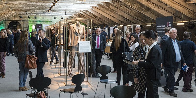 A group of people looking at fabric design exhibits as part of Future Fashion Factory