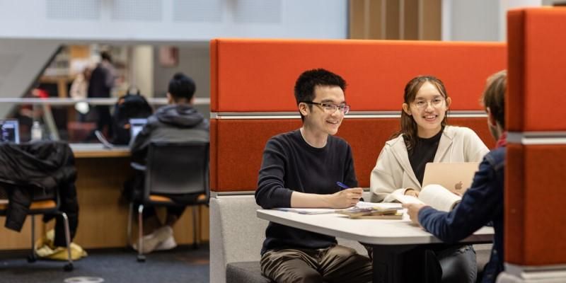 Students sitting in library booth