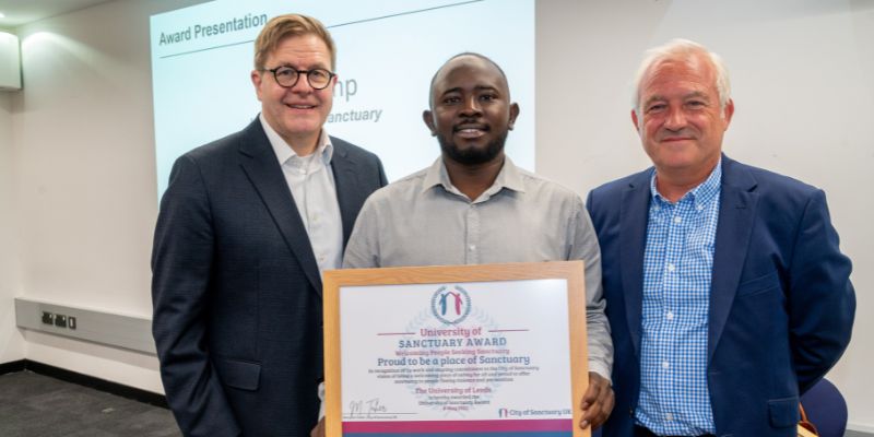 University of Leeds Pro-Vice Chancellor for Student Education,Jeff Grabill, with Fathelrahman Eltigani and Ian Kemp from Leeds City of Sanctuary, stood holding the University's City of Sanctuary Award.