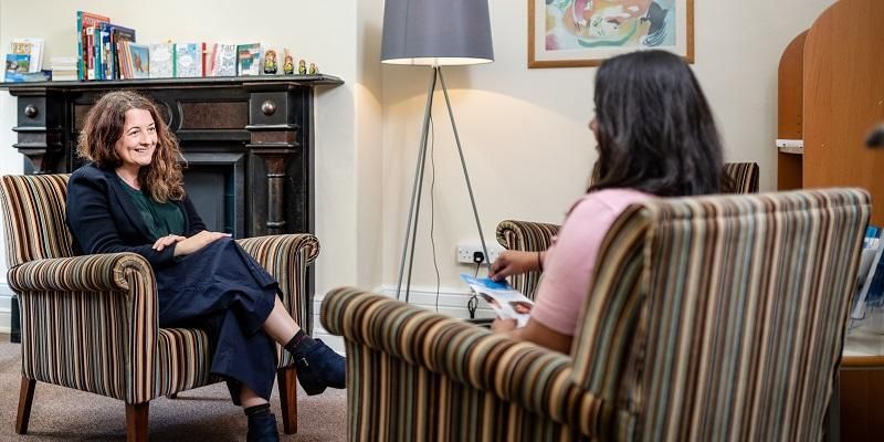 Two people sat on armchairs chatting